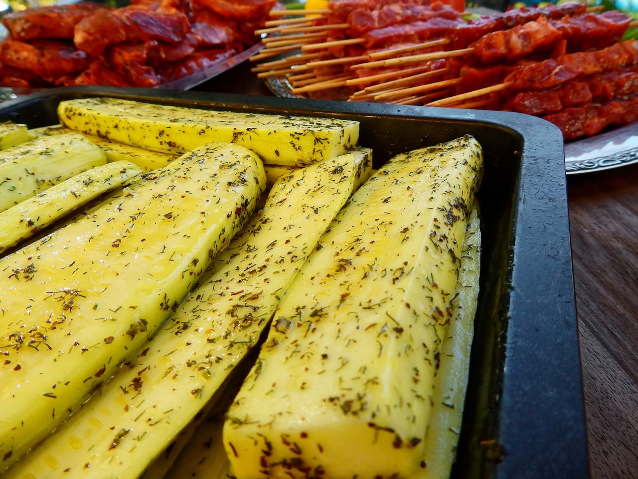 Sliced squash seasoned prepped to grill.