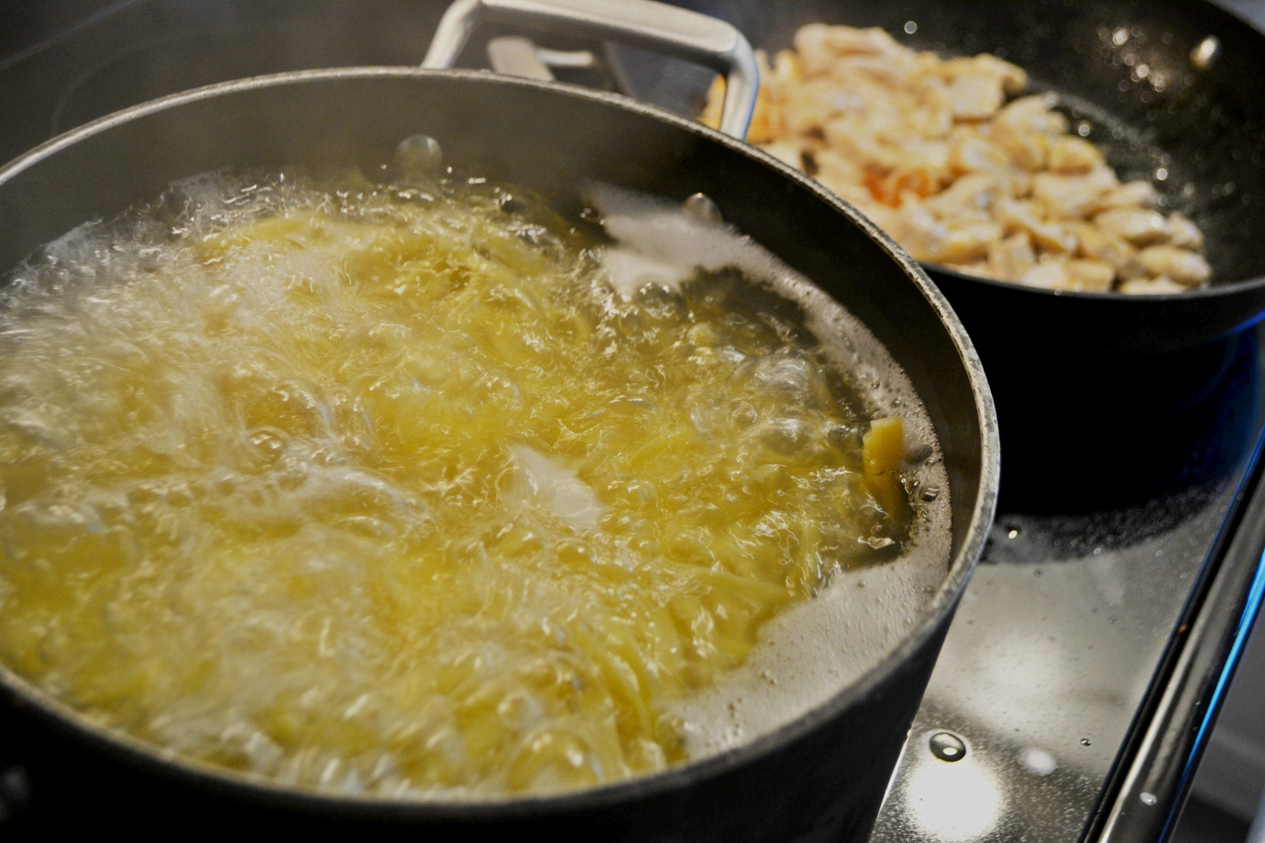 A pot of pasta boiling on a stove.