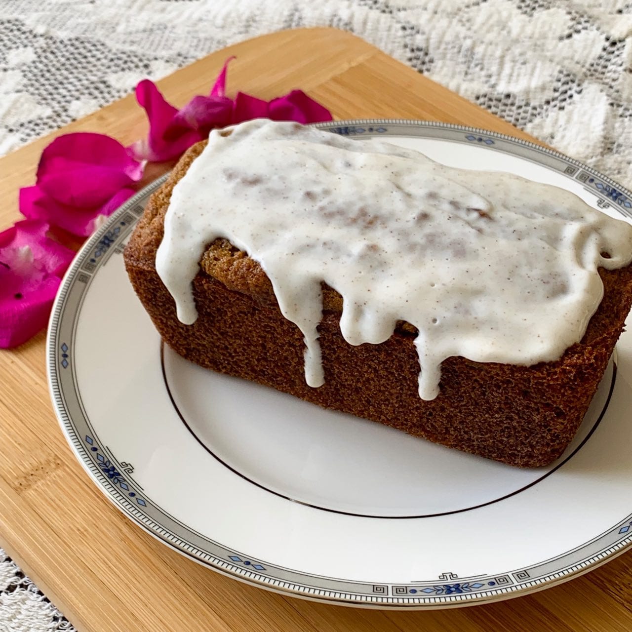 A loaf of carrot cake topped with yogurt frosting.